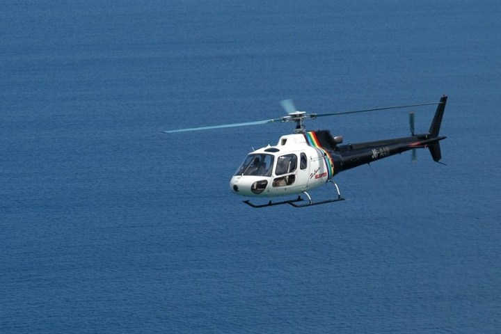 a small airplane flying over a body of water